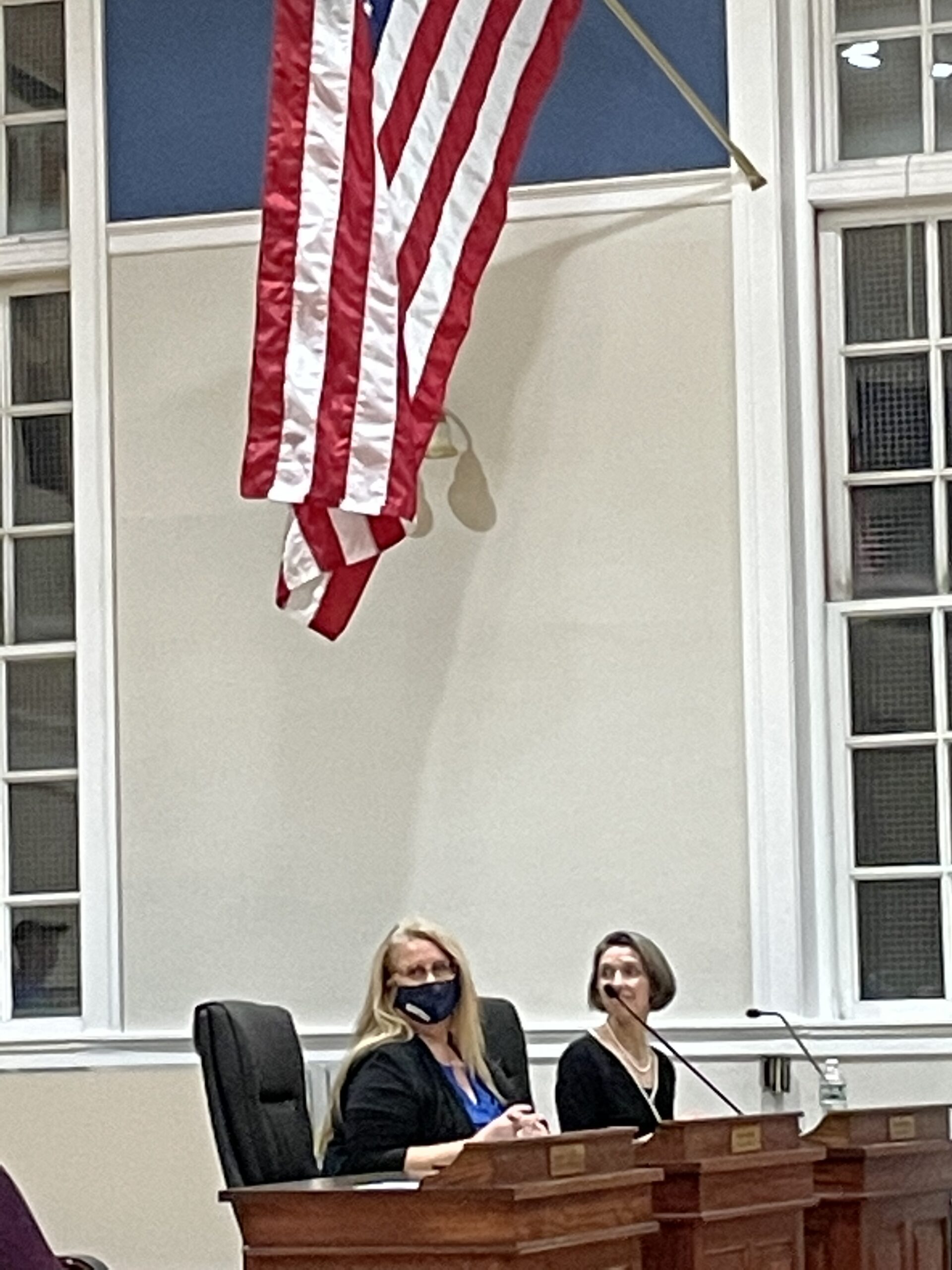 Elizabeth is seated at Town Hall at the first Council meeting of her term. Seated next to her is Meredith Boercke, Councilor for District 5 and the new Chair of the Council. 